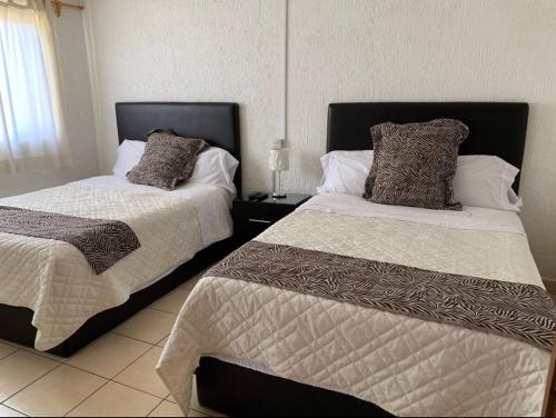 two beds sitting next to each other in a bedroom at Agradable y amplio depa cerca del metropolitano in Guadalajara