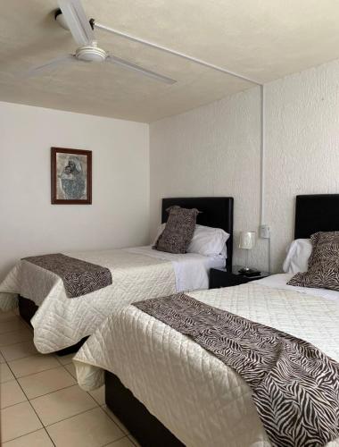 two beds in a hotel room with two bedsskirts at Agradable y amplio depa cerca del metropolitano in Guadalajara