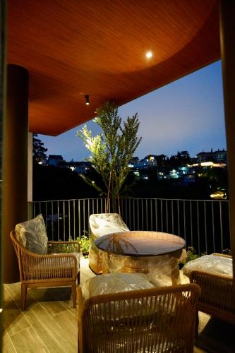 a balcony with a table and chairs and a large window at Là Yên Villa - Đà Lạt in Ấp Ða Lợi