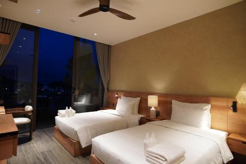 a hotel room with two beds and a window at Là Yên Villa - Đà Lạt in Ấp Ða Lợi
