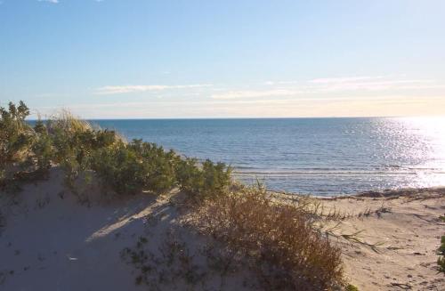 a sandy beach with the ocean in the background at Beach Stayz Semaphore Three Bedroom Apartment in Port Adelaide