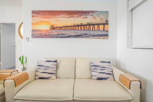a living room with a white couch and a pier at Beach Stayz Semaphore Three Bedroom Apartment in Port Adelaide