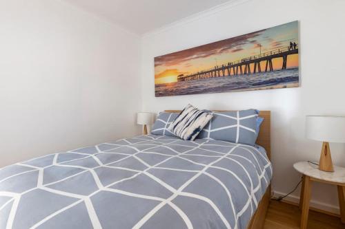 a bedroom with a bed and a pier at Beach Stayz Semaphore Upstairs Two Bedroom Apartment in Port Adelaide