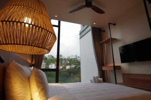 a bedroom with a bed with a ceiling fan and a window at Là Yên Villa - Đà Lạt in Ấp Ða Lợi