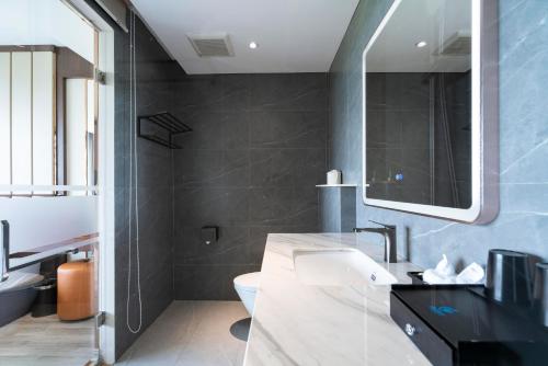 a bathroom with a sink and a mirror at Ruby Hotel Van Don in Tài Xá