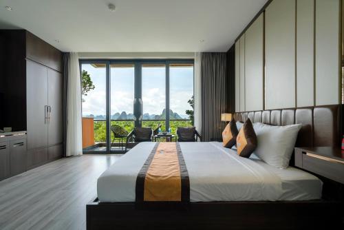 a bedroom with a large bed with a large window at Ruby Hotel Van Don in Tài Xá