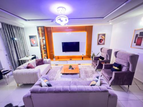 a large living room with couches and a tv at Kings Heights Apartments in Ikeja