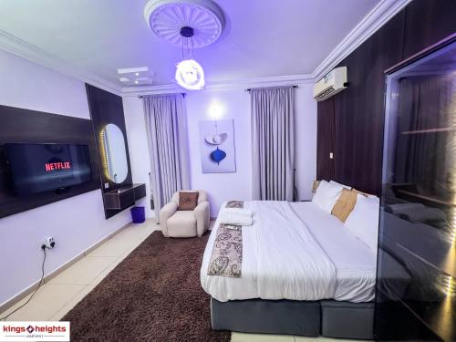 a hotel room with a bed and a tv at Kings Heights Apartments in Ikeja