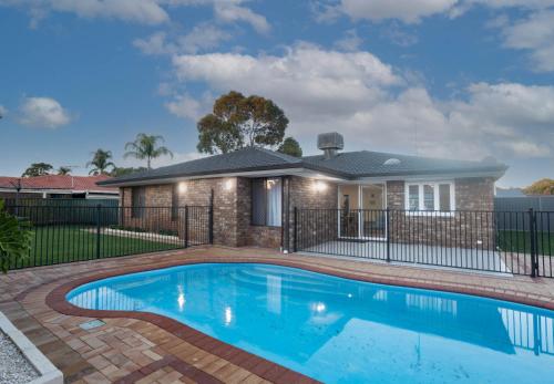 a house with a swimming pool in front of a house at Family Retreat in Perth