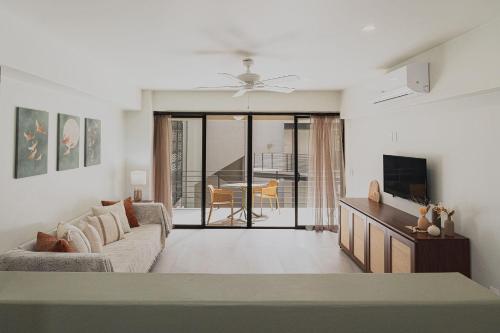 a living room with a couch and a tv at Brand New Condo near beach in Santa Cruz Huatulco