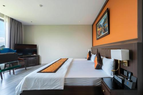 a hotel room with a large bed and a television at Ruby Hotel Van Don in Tài Xá