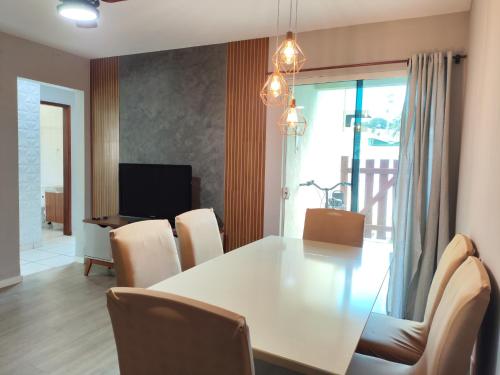 a dining room with a white table and chairs at Apartamento Térreo 2 Quartos Com Clube Privativo - Condomínio Marina Clube in Cabo Frio