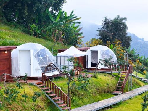 a couple of tents on a grassy hill at Raisuayang in Mon Jam