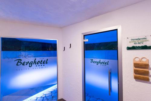 a room with two doors with the words baptized at Berghotel - Sexten in Sesto