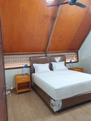 a bedroom with a bed with white sheets at Freddies Villas Sabang in Sabang
