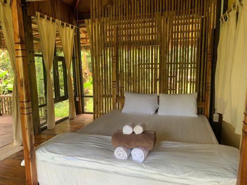 a bed with two towels and a stuffed animal on it at Farm House in Phu Quoc