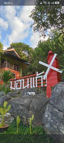 a red and white sign with a clock in front of a house at Monkeaw and Climber's Camp in Mae On