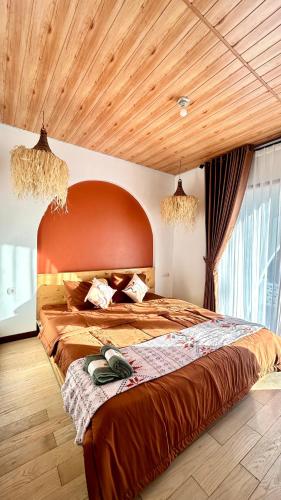a bedroom with a large bed with a red headboard at Sun kissed Dieng Villa in Dieng