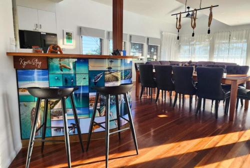a dining room with a bar with chairs around it at Bushys Hilltop (Kingfisher Bay, Kgari) in K'gari Island (Fraser Island)