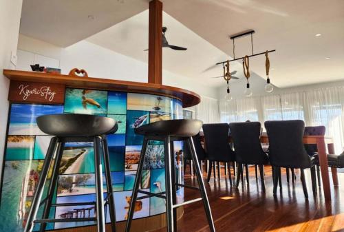 a dining room with a bar with black stools at Bushys Hilltop (Kingfisher Bay, Kgari) in K'gari Island (Fraser Island)
