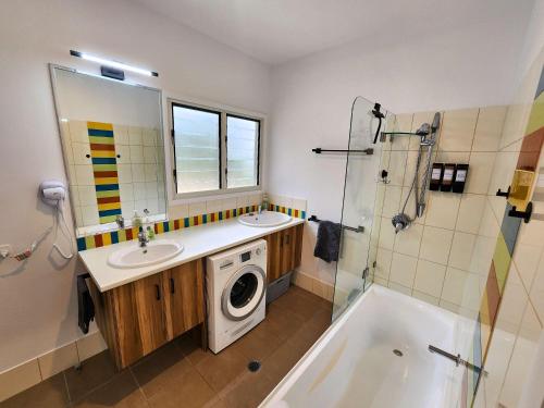 Bushys Hilltop (Kingfisher Bay, Kgari) في فريزر آيلاند: حمام مع مغسلة وغسالة ملابس