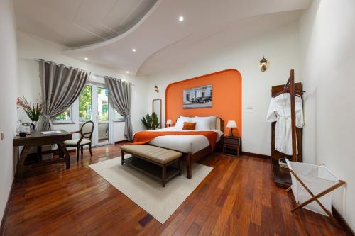 ハノイにあるAnamoi Villa An Duong Tay Ho 5min to West Lake 6BRのベッドルーム(オレンジと白のベッド、デスク付)