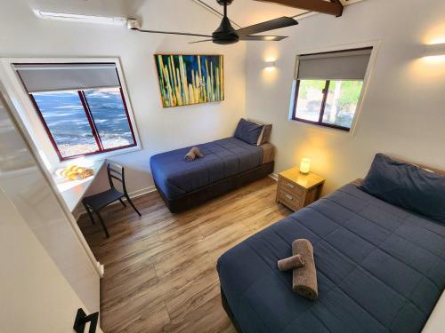 a bedroom with a bed and a couch and windows at 719 Cooloola Villa at Kingfisher Bay K'gari Fraser Island in K'gari Island (Fraser Island)