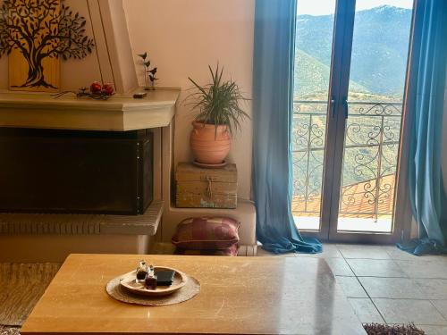 a living room with a table and a large window at Pandoras House Arachova in Arachova