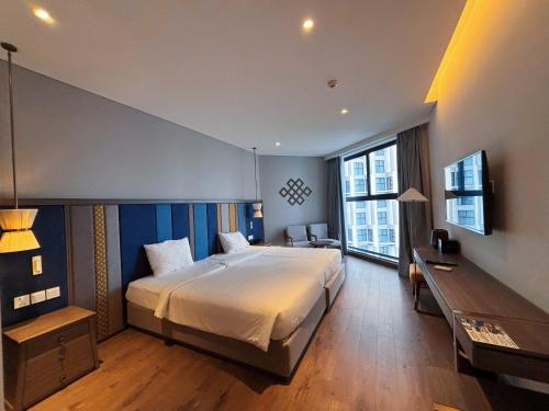 a bedroom with a large bed and a television at Condotel SeaSide - Apec Mandala Cham Bay Mui Ne in Mui Ne