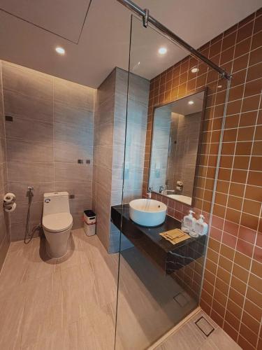a bathroom with a toilet and a sink and a shower at Condotel SeaSide - Apec Mandala Cham Bay Mui Ne in Mui Ne