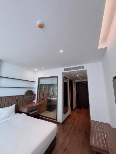a bedroom with a white bed and a large window at Condotel SeaSide - Apec Mandala Cham Bay Mui Ne in Mui Ne