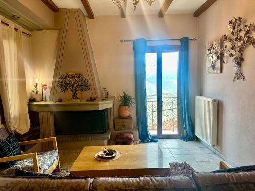 a living room with a couch and a table and a window at Pandoras House Arachova in Arachova