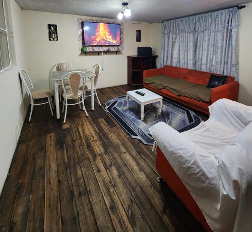 un soggiorno con un divano e un tavolo di Departamento Completo Confortable a Latacunga