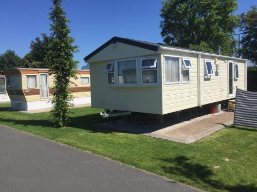 une petite maison est garée dans une cour dans l'établissement Camping Ter Hoeve, à Bredene