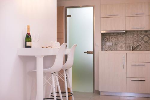 a kitchen with a table and two white stools at Estian Deluxe in Limenaria