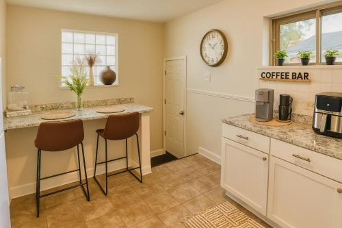 a kitchen with a coffee bar and a clock on the wall at Urban Oasis in the Heart of STL in Saint Louis