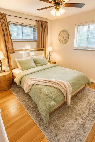 a bedroom with a large bed and a clock on the wall at Urban Oasis in the Heart of STL in Saint Louis