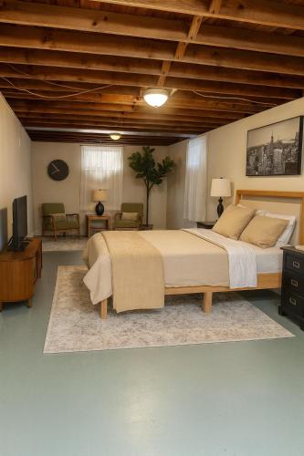a bedroom with a large bed and a living room at Urban Oasis in the Heart of STL in Saint Louis