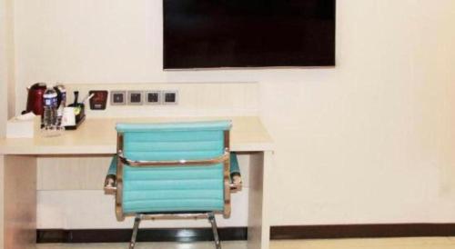 a blue chair sitting in front of a desk at 7 Days Premium Beijing Dabaotai Metro Station Luhua Road in Beijing