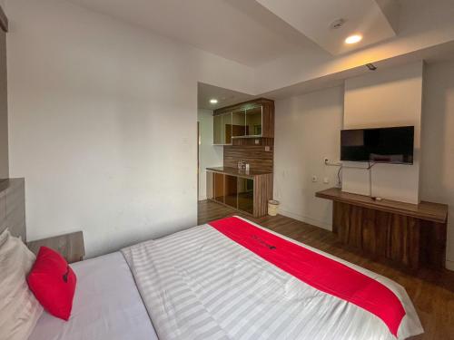 a bedroom with a large white bed with red pillows at RedDoorz Apartment near Exit Toll Colomadu in Solo