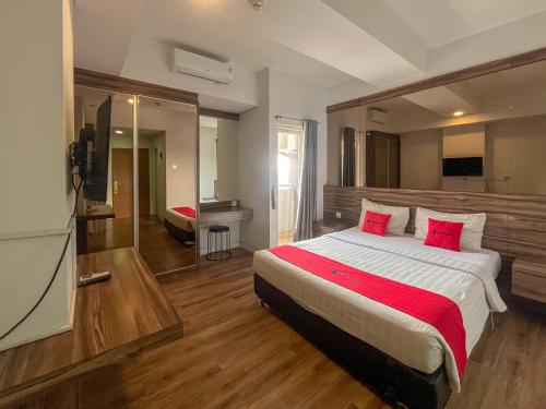 a bedroom with a large bed with red pillows at RedDoorz Apartment near Exit Toll Colomadu in Solo