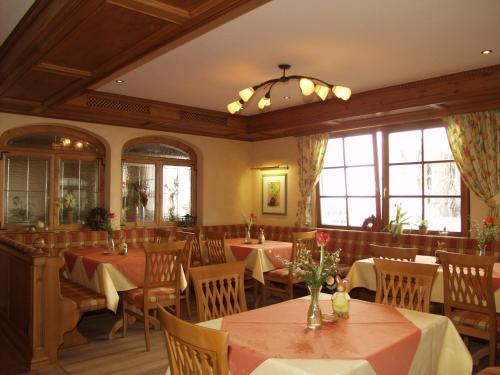 a dining room with tables and chairs and windows at Landgasthof Goldene Rose in Grub am Forst