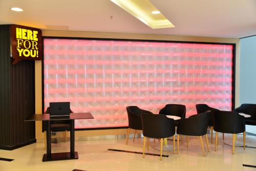 a conference room with a red wall with chairs and a table at Park Inn by Radisson Ankara Cankaya in Ankara