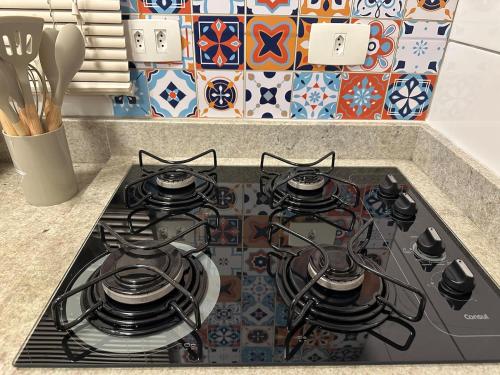 a stove top with four burners on it in a kitchen at Apartamento pé na areia in Santos