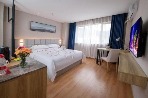 a hotel room with a large bed and a desk at danfeng kelly hotel in Shenzhen