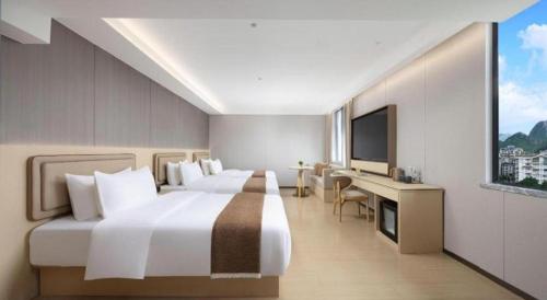 a hotel room with two beds and a television at Immersing Hotel Guilin Two Rivers and Four Lakes Dongxi Alley in Guilin