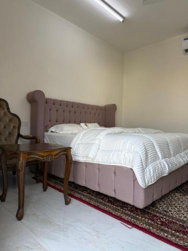 a bedroom with a large bed and a table at استراحة القمة in Ḩilf