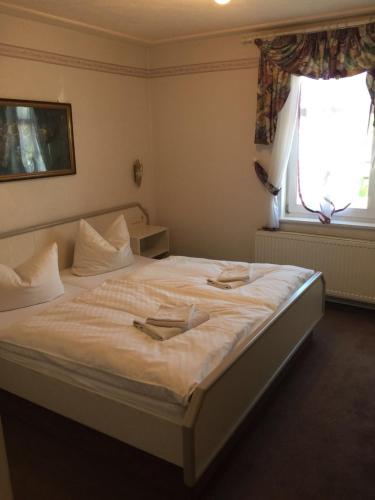 a bedroom with a large white bed with a window at Hotel Alte Posthalterei in Creuzburg