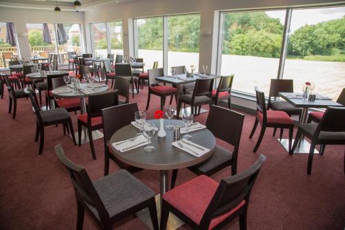 a dining room table with chairs and tables at Ramada Milton Keynes in Milton Keynes