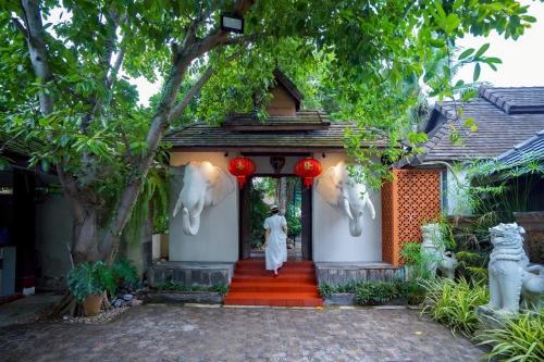 a person walking out of a building with a doorway at Laan Mai Fai Chang Resort in Chiang Mai
